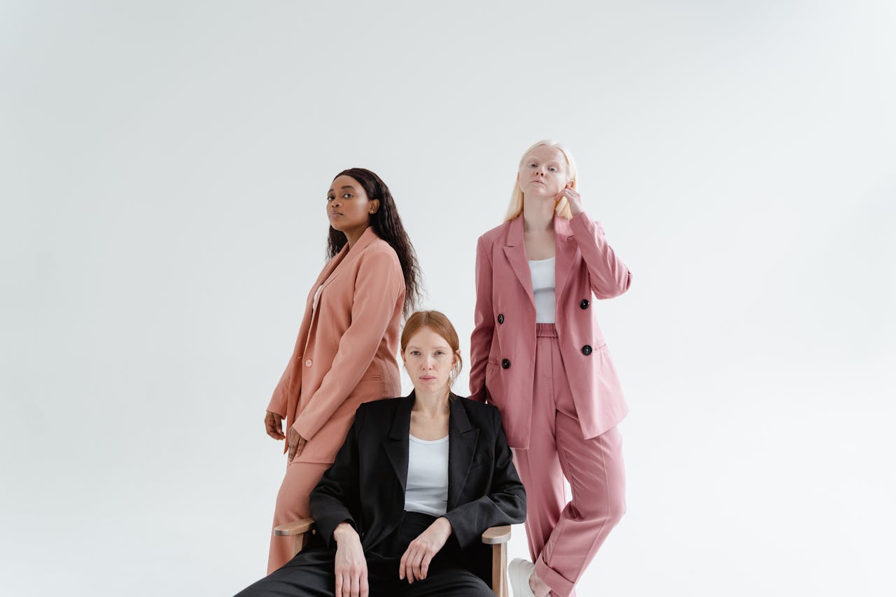 about-us Three diverse businesswomen in stylish suits on a studio white background, exuding confidence.